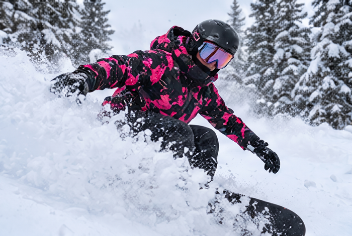 Snowboarder carving powder in the Neon Pink colorway